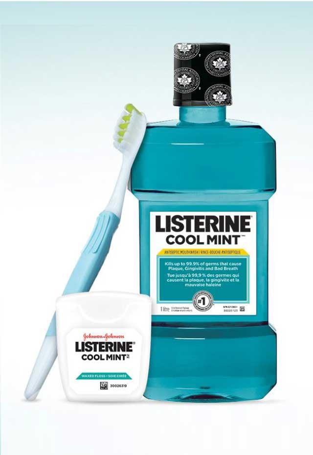 Flacon du rince-bouche Listerine à côté d'une brosse à dents et de la soie dentaire